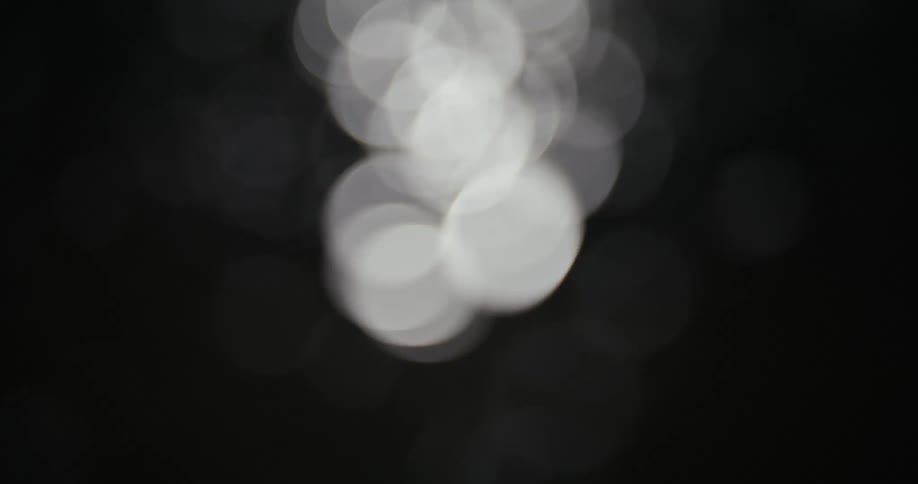 Several rapidly passing lights are blurred on a black background