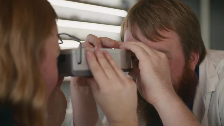Doctor using a device checking the patients eyes