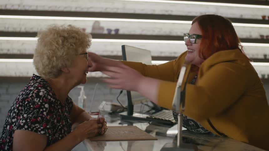 An ophthalmologist helps an elderly lady with her glasses