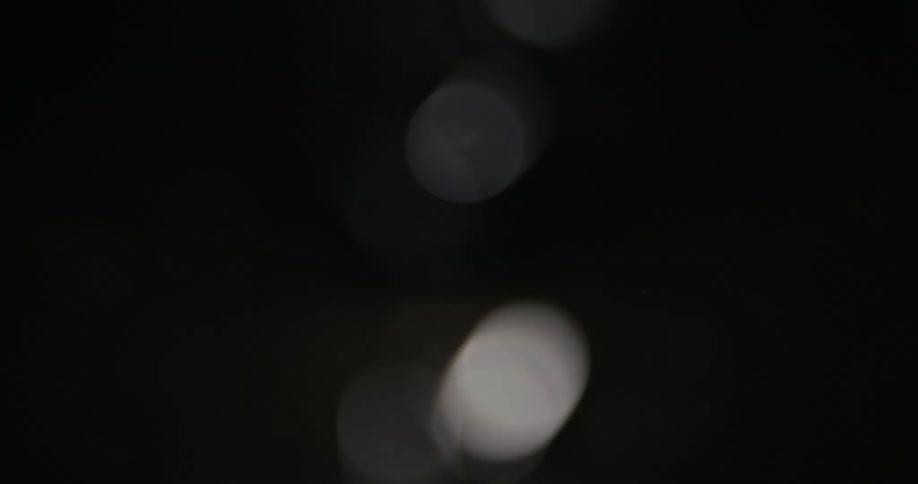 Blurry out of focus sparks fall down on a dark background