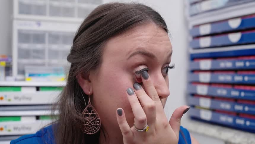 Portrait of a woman putting contact lenses in her eye