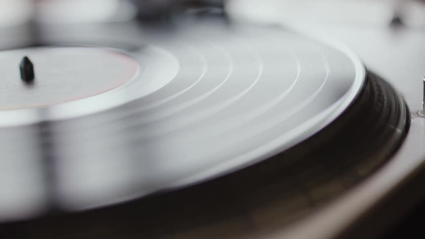 A closeup of a record player playing a record