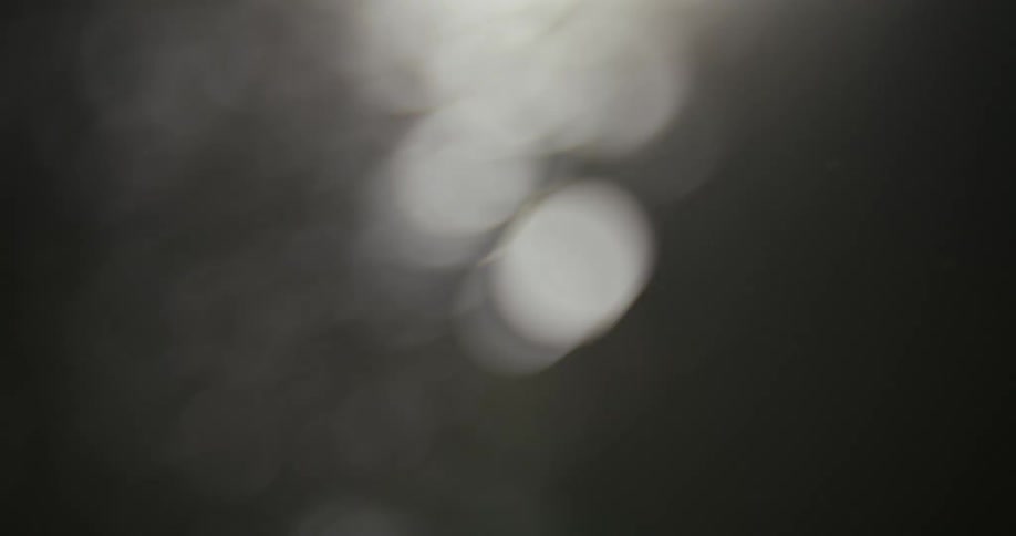 Black and white footage of sparks falling down at night