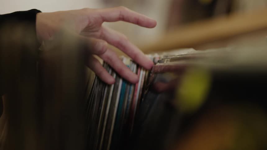 Hand of a man viewing vinyl records