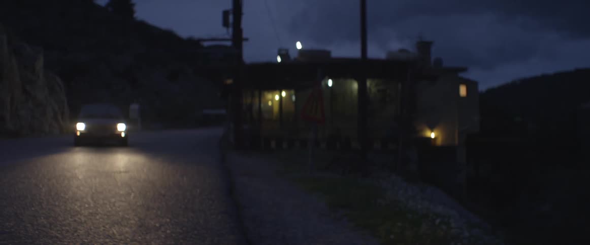 Car driving down the street at night