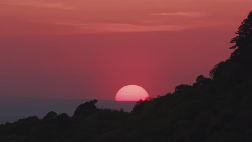 A sunset with the sun partially visible above the horizon