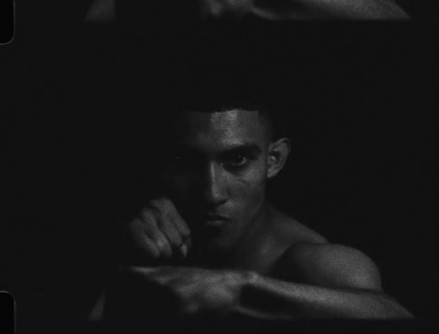 Boxer practicing outdoors looking at the camera caught on vintage film