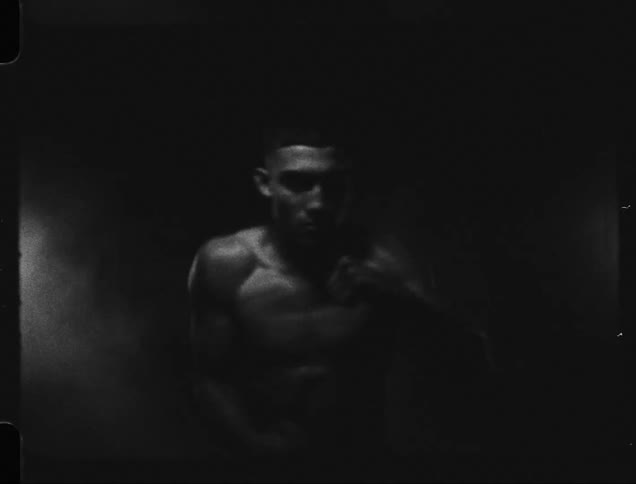 Concentrated man without shirt throwing punches training boxing
