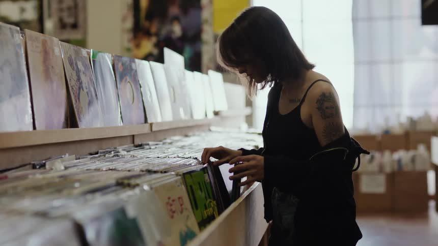 A woman browsing vinyl records on a store