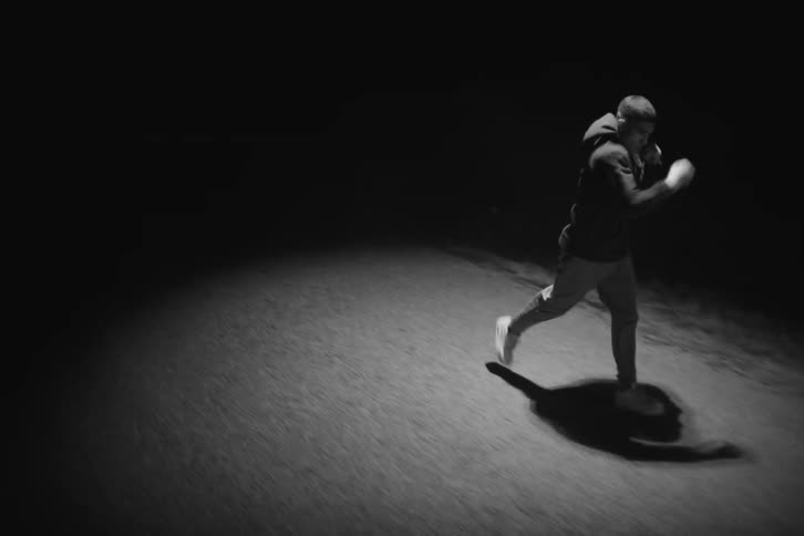 Man running on asphalt and doing boxing moves
