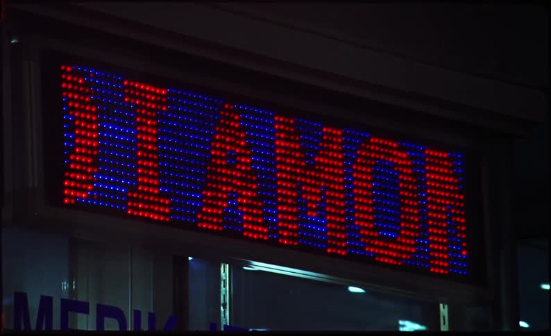 A red and blue digital sign on the side of a building
