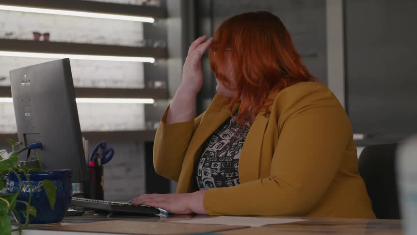 A female optical store employee typing on a desktop computer keyboard