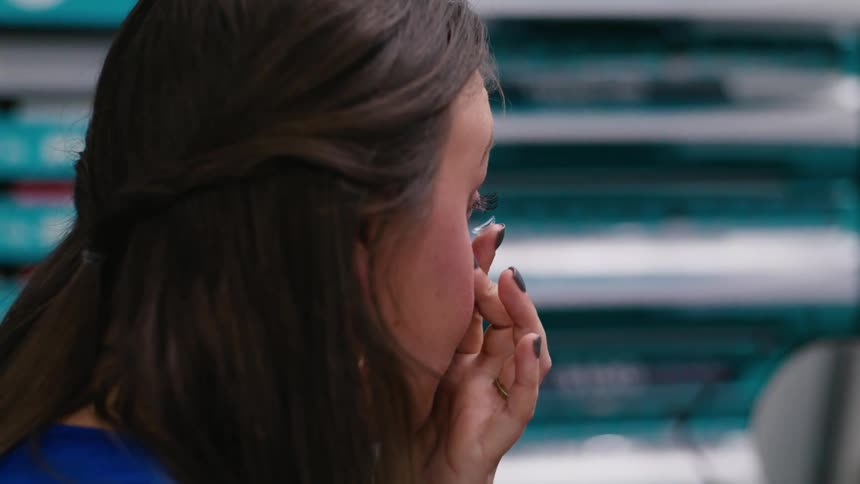 Woman puts on contact lens en her eye at the ophthalmologist