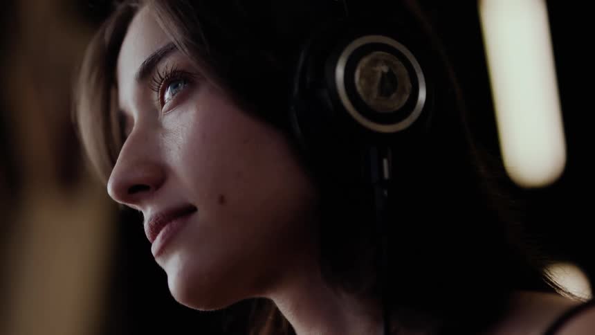Side portrait of a woman using headphones and enjoying