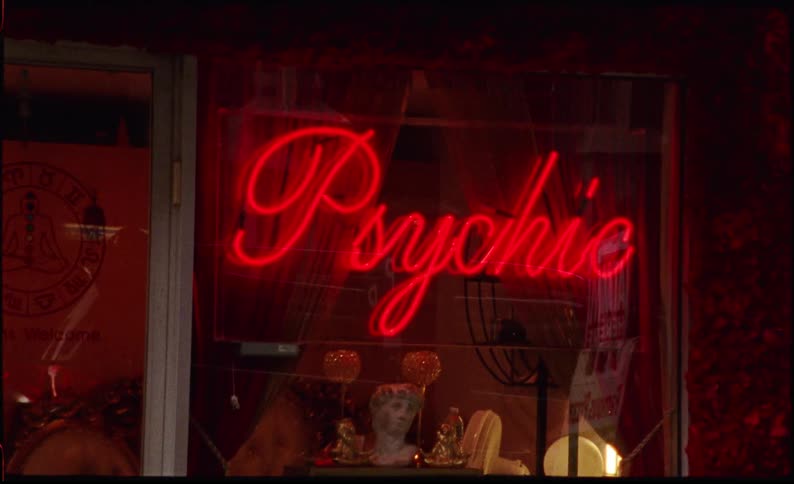 Cars drive past a psychic storefront