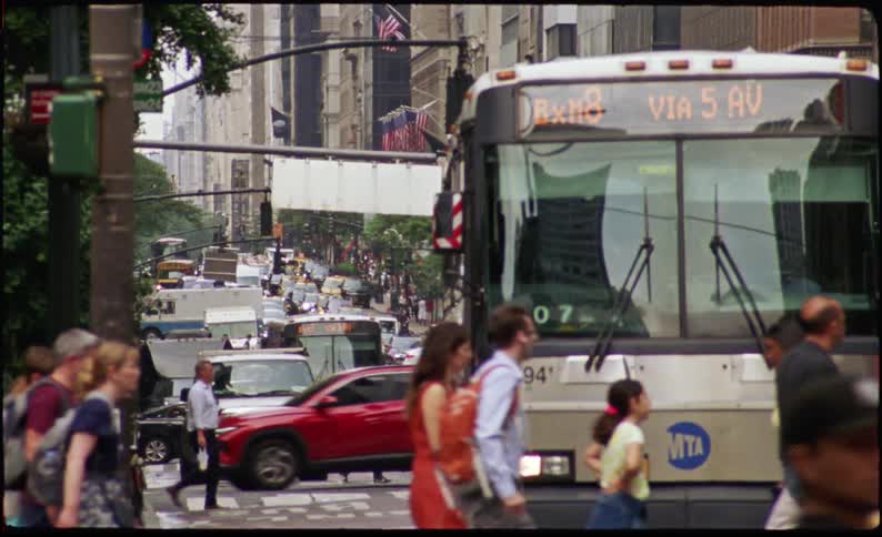 Crowds of pedestrians crossing a street in a busy city