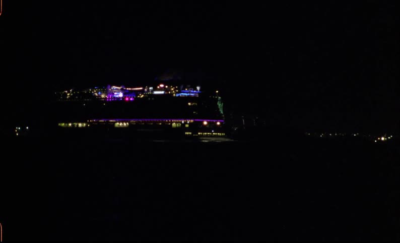 A cruise ship illuminated at night floating on the water