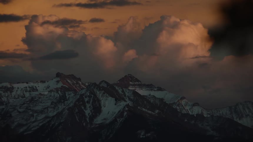 Large clouds float over a mountain range