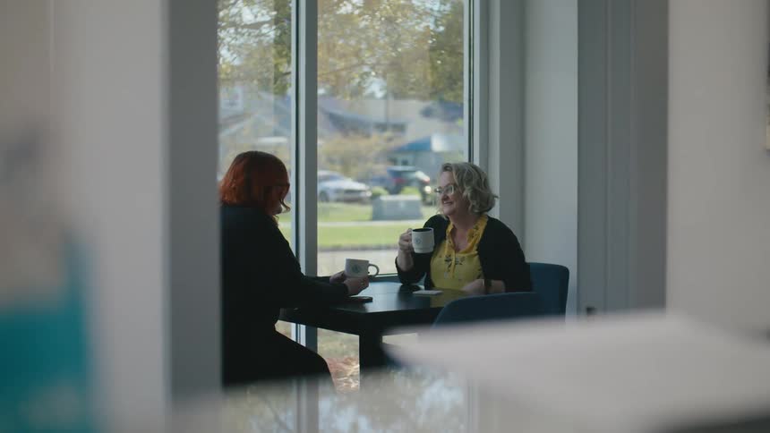 Two women drink coffee in the cafe