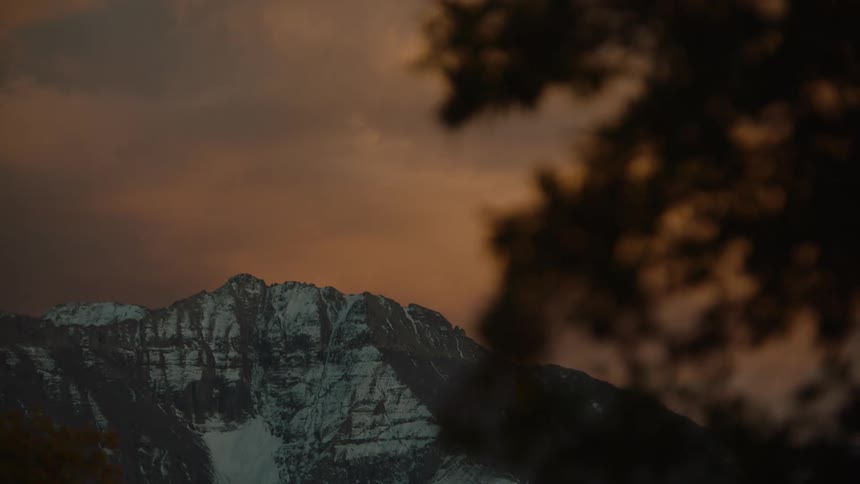 Snowcovered mountains on a cloudy reddish morning