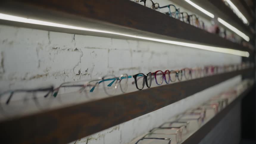 A row of eyeglasses displayed on a shelf