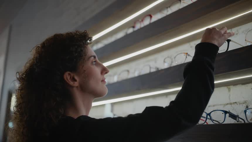 A woman organizing eyeglasses on a shelf