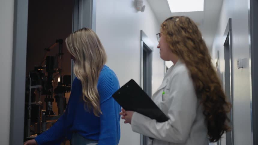 Doctor in a lab coat walking with her patient to the clinics office