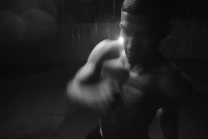 Boxer practicing under a spotlight at night