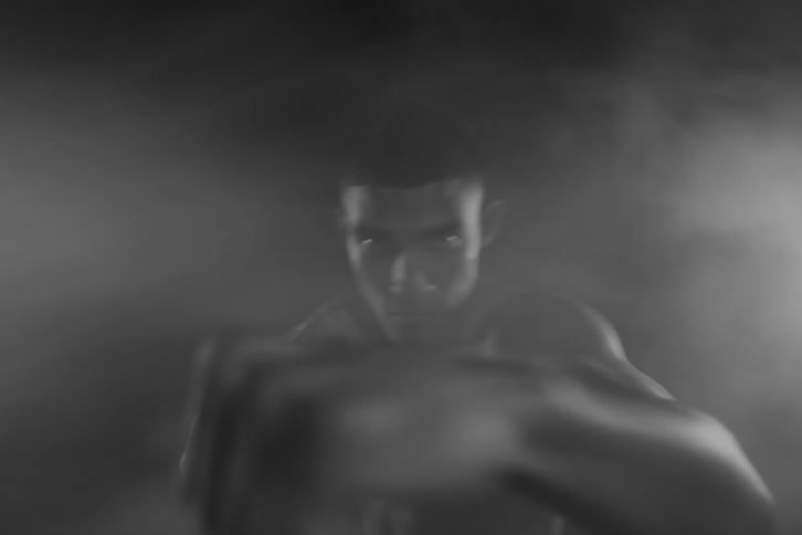 A man is shadow boxing in the fog