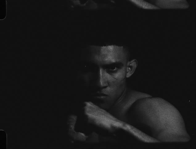 Close up of a shirtless boxer looking at the camera