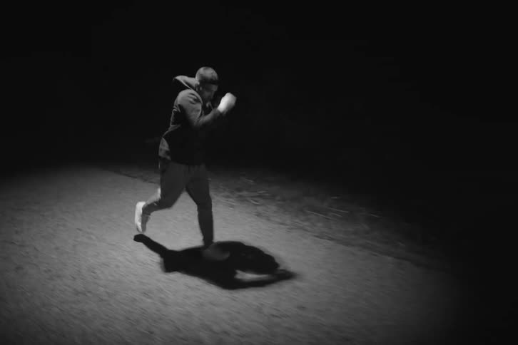 A man is jogging while punching at night