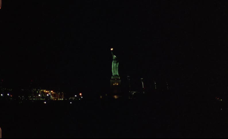 The statue of liberty is lit up at night