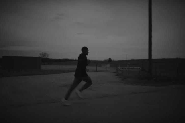 A man jogs down a rural road at dusk