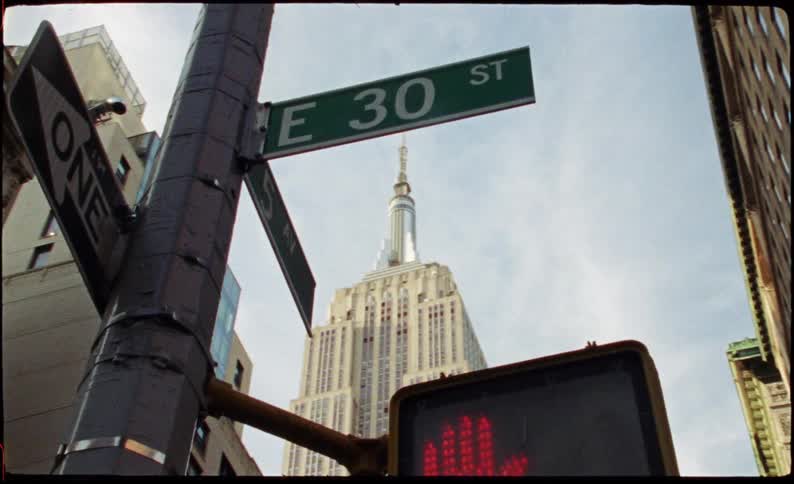 Sign post with stop sign for pedestrians and skyscrapers in the background in a metropolis
