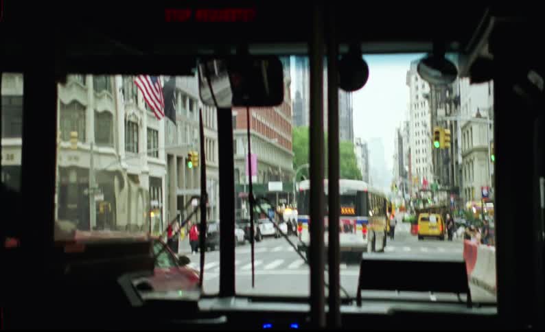 A view of an interior of a bus that is driving on a busy city street