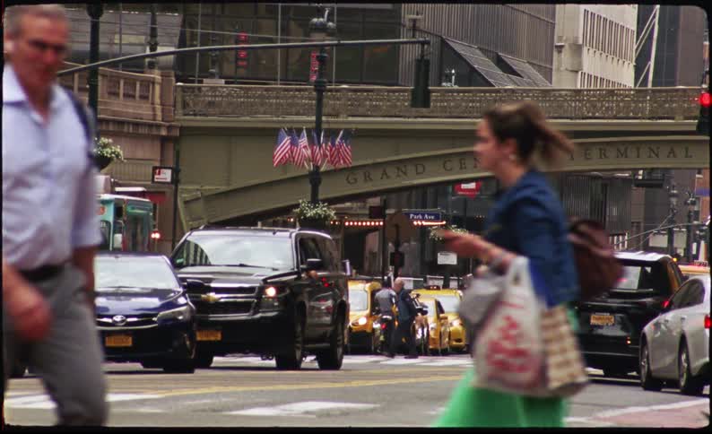 Street in a metropolis with pedestrians and heavy vehicle traffic