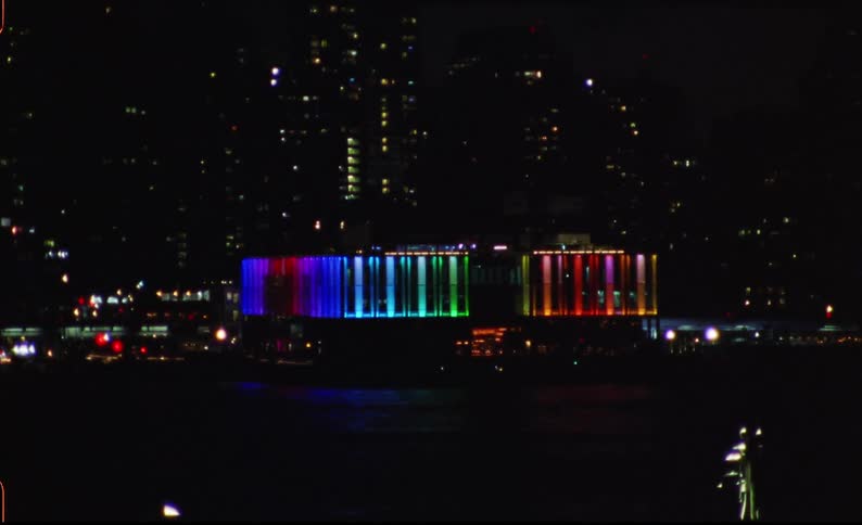 Panorama of a metropolis seen at night with a building in colorful neon colors