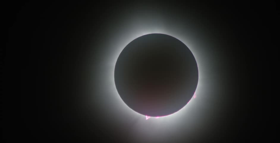 A solar eclipse reveals a dark silhouette of the moon covering the sun