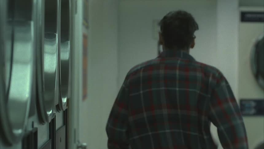 A man runs to the restroom in the laundromat
