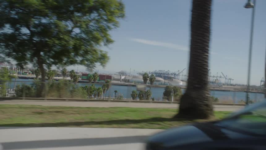 A view from a moving vehicle of a square facing the sea