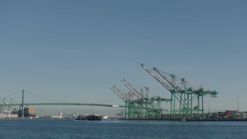 Panorama of an ocean with a bridge on the horizon and a container distribution center port