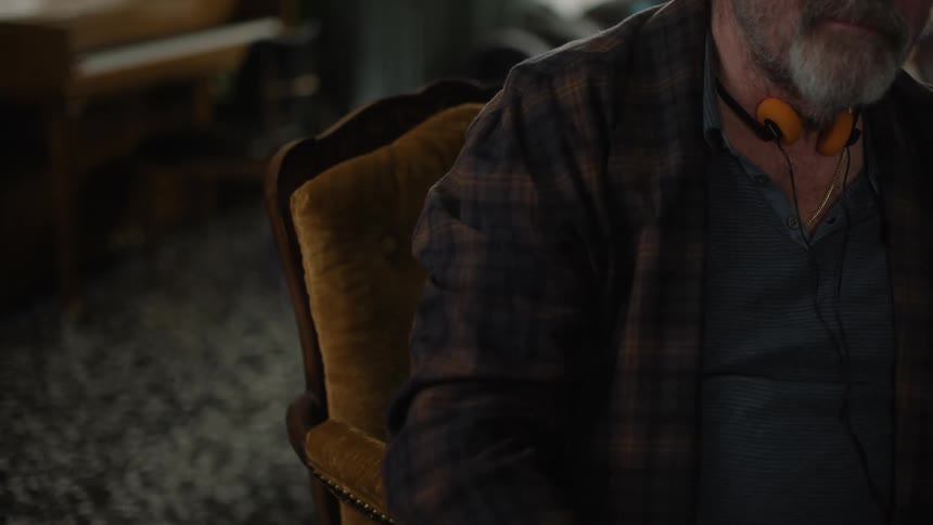 A man is wearing headphones in the chair