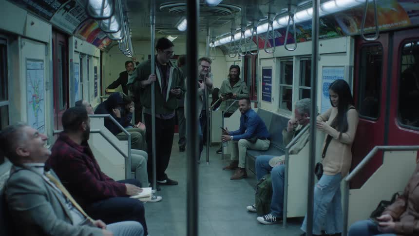 A group of passengers are laughing while riding the subway