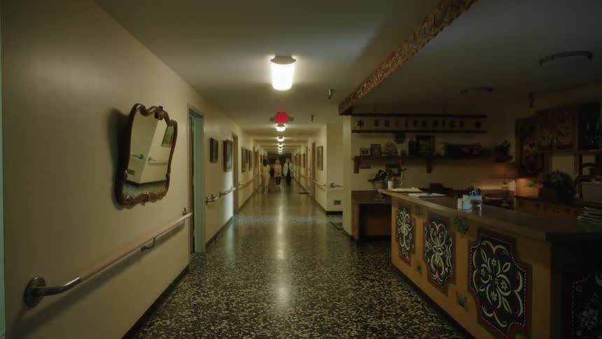 A doctor walks down a hallway with a couple of people