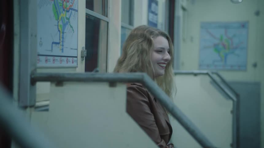 A woman is laughing while riding the subway
