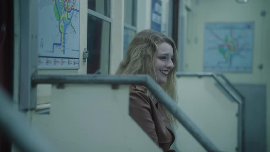 Woman sitting on a train seat laughing