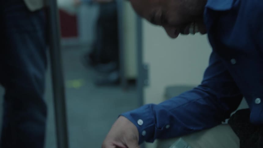 A man in a blue shirt is sitting and is laughing a lot