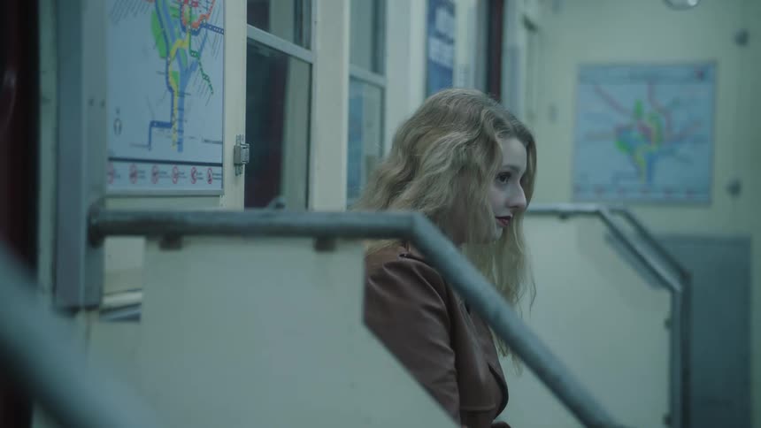 A woman sitting on a subway sees something that makes her laugh