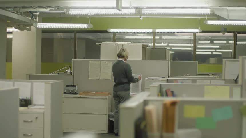 Woman next to a printer inside a brightly lit empty office