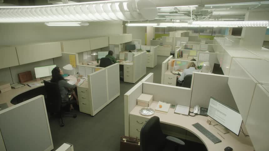 Employees in cubicles work at their computers
